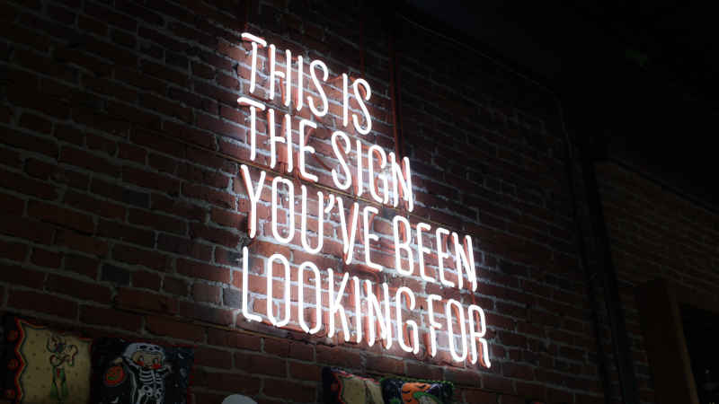 Beleuchteter Schriftzug an einer Wand mit dem Text "This is the sign you`ve been looking for"